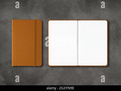 Leather closed and open lined notebooks on dark concrete background Stock Photo
