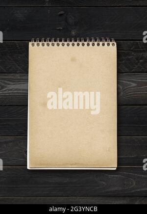Closed spiral Note book on a black wood table Stock Photo