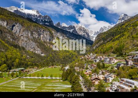 The Improbable aerial landscape of village Molveno, Italy, snow covered mountains Dolomites on background, roof tops of chalet, Stock Photo