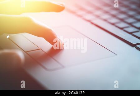 Hands are using a touchpad of laptop, close up picture and sunshine Stock Photo