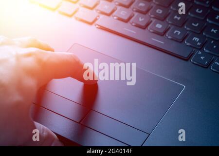 Hands are using a touchpad of laptop, close up picture and sunshine Stock Photo