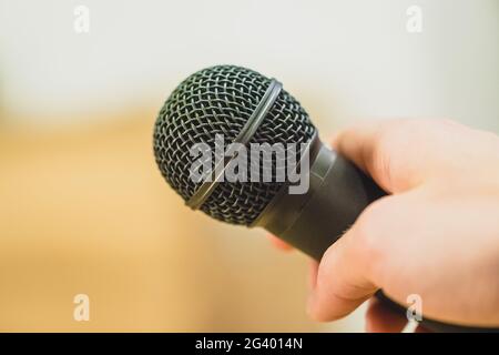 Interview: Journalist is holding a microphone in his hand. Close up. Stock Photo