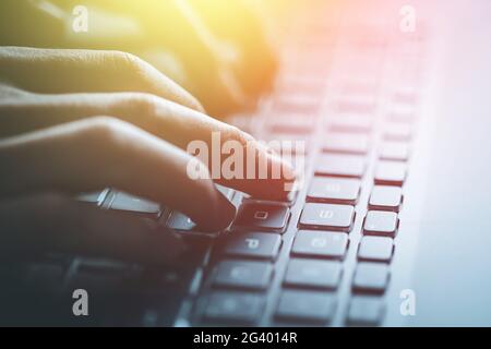 Hands are typing on a laptop keyboard, close up picture and sunshine Stock Photo