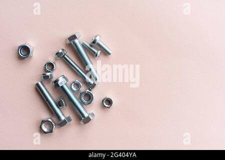 silver stainless steel nuts and bolts flat lay on the table, minimalistic concept Stock Photo