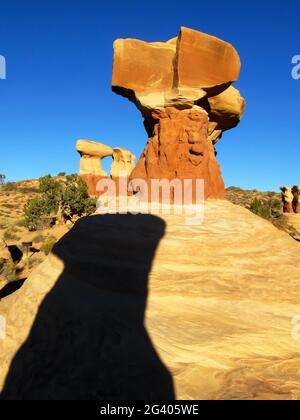 Colorful sandstone hoodoos, in the Devil’s Garden, Escalante, Utah, USA, with the shadow of another hoodoo in the foreground Stock Photo