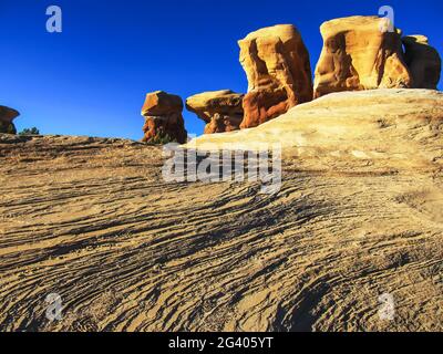 Low angle view of the hoodoos in the Devil’s Garden, Escalante, Utah, USA, with the exfoliating Navajo Sandstone in the foreground Stock Photo
