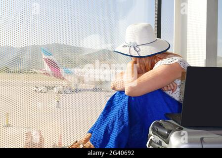 Female freelancer at airport. woman working with laptop in airport until departure. Stock Photo