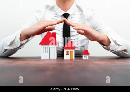 Protecting Hands Over House - Home Security And Protection Concept. hands holding paper, family home, homeless housing and home Stock Photo