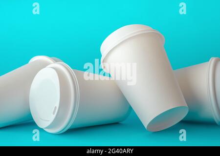 Spilled White Paper Coffee Cups on Green Background, Paper Coffee Cup Template. Stock Photo