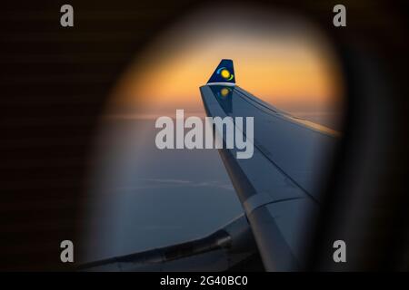 View out of window of a RwandAir Airbus A330-300 airplane with sun logo on winglet at sunrise, on the flight from Brussels International Airport (BRU) Stock Photo