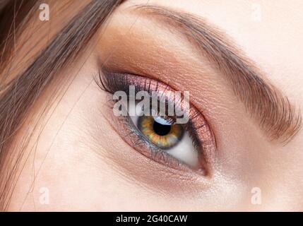 Closeup macro shot of  smiling female eye with  pink  eyes shadows Stock Photo