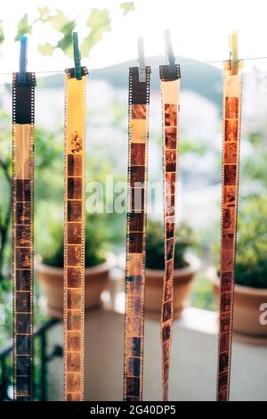 The film strip 135 is dried on clothespins. Vintage background of film photography. Stock Photo