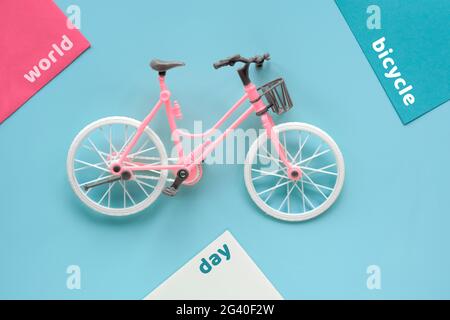 World Cycling Day, Bicycle Day on June 3. Toy model town bike with shadow on mint blue background. Flat lay, top view, minimal retro vintage concept Stock Photo