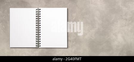 Blank open spiral notebook isolated on concrete banner Stock Photo