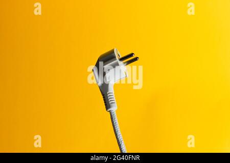 Electric plug closeup on yellow background Stock Photo