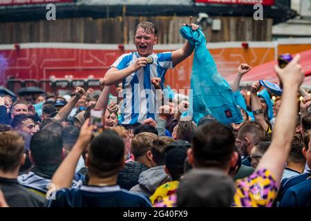 London, UK. 18th June, 2021. Scotland football Fans gather in Leicester Square despite the rain and lack of tickets. They are meeting up to drink and sing songs in good spirits before their Euro 2020 match at Wembley against England tonight. Credit: Guy Bell/Alamy Live News Stock Photo