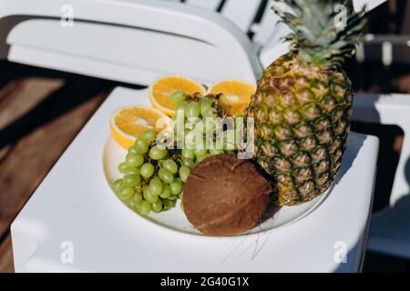 Fresh fruits in soft focus on tray near swimming pool, welcome fruit Stock Photo