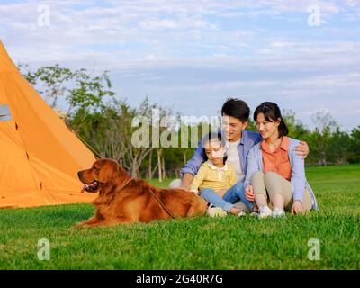 Happy family of three and pet dog in the park high quality photo Stock Photo