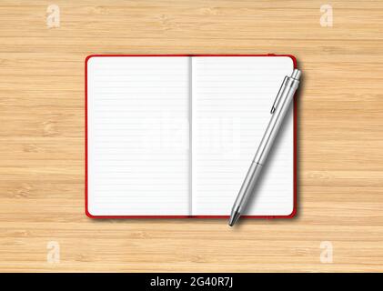 Red open lined notebook with a pen isolated on wooden background Stock Photo