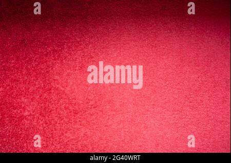 The texture of the red carpet carpet photographed up close with shadows on it. Stock Photo