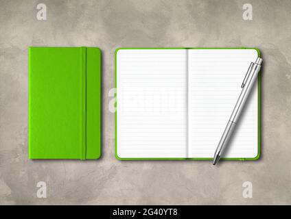 Green closed and open lined notebooks with a pen on concrete background Stock Photo