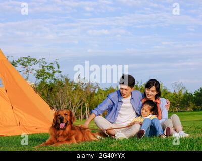 Happy family of three and pet dog in the park high quality photo Stock Photo