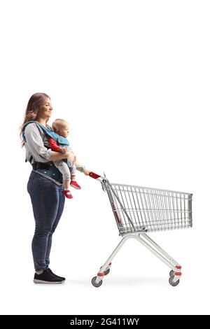 Full length shot of a mother with a baby in a carrier pushing a shopping cart isolated on white background Stock Photo