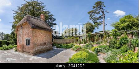 Colourful cottage gardens and cottage at The Newt, near Bruton, Somerset, UK on 15 June 2021 Stock Photo