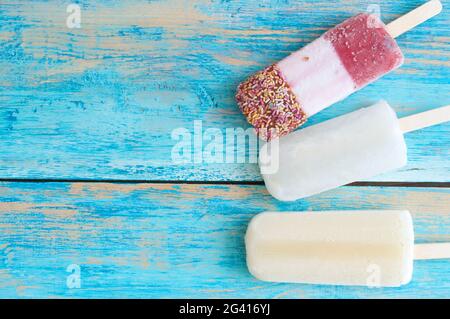 Frozen assorted ice lollies on a wooden background Stock Photo