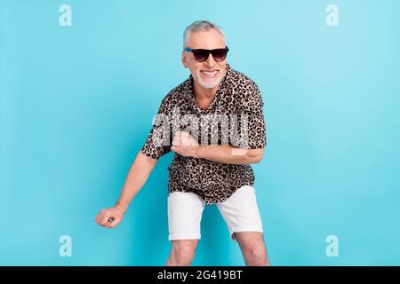 Photo of funny funky happy old cheerful man dance good mood smile wear sunglass isolated on blue color background Stock Photo