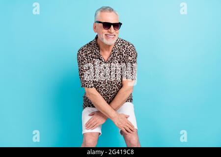Photo of funky positive happy old man dance wear sunglass free time weekend isolated on blue color background Stock Photo