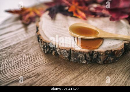 Maple syrup sugar liquid in wooden spoon from Quebec restaurant sugar shack called Cabane a sucre maple trees sap farm. Canadian delicacy sweet Stock Photo