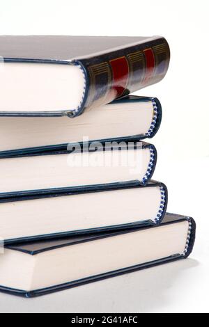 Stack of books, five books placed on top of each other, detail of book spines, isolated on white background Stock Photo