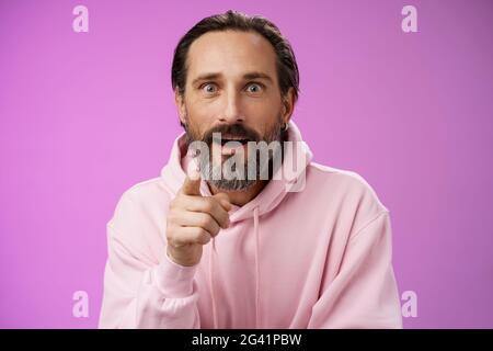 Fascinated amused european bearded mature guy widen eyes shocked open mouth recognize person pointing camera index finger surpri Stock Photo