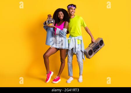 Full length body size view of handsome beautiful cheerful couple having fun deejay event isolated on bright yellow color background Stock Photo