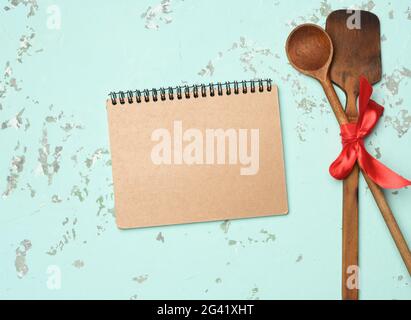 Spoon and spatula tied with blue ribbon on green background Stock Photo