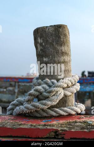 Rope coiled around a wooden post on a boat at Dungeness Stock Photo