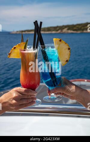Detail of two colorful cocktails in the hands of passengers on board the cruise ship, Vis, Vis, Split-Dalmatia, Croatia, Europe Stock Photo