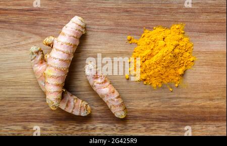 Turmeric root and spice powder on a cutting board Stock Photo