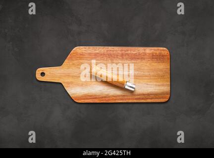 Wooden cutting board and pocket knife on concrete table Stock Photo