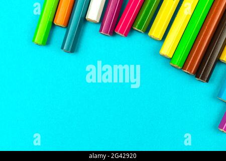 Different colour pencils lying on a bright desktop table top view, school stationery background concept Stock Photo