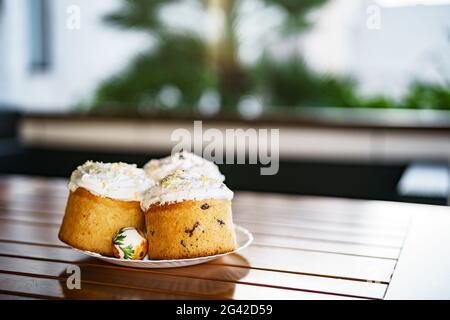 Plate with Easter cakes and decorated Easter eggs. Stock Photo