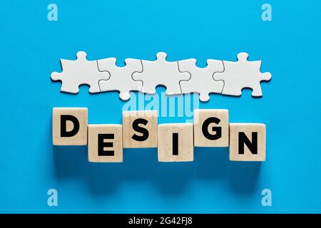 Web design or graphic design business or occupation concept. The word design on wooden cubes with a connected line of jigsaw puzzle. Stock Photo