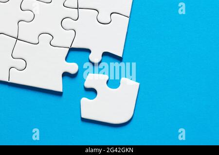 One missing puzzle piece with blue background with copy space. Connection or separation concept. Stock Photo