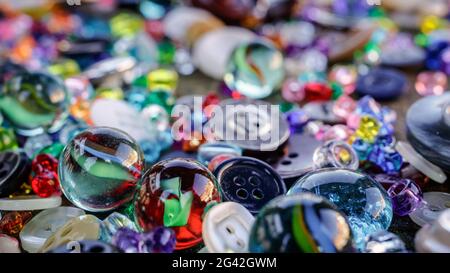 A group of randomly scattered beads, buttons and marbles Stock Photo