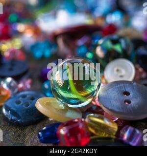 A group of randomly scattered beads, buttons and marbles Stock Photo