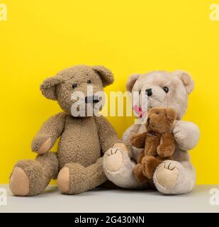 Teddy bears sitting on a yellow background, family Stock Photo - Alamy