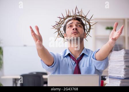 Young male employee wearing prickly wreath on head Stock Photo