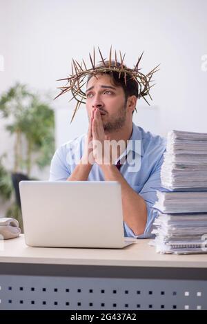 Young male employee wearing prickly wreath on head Stock Photo