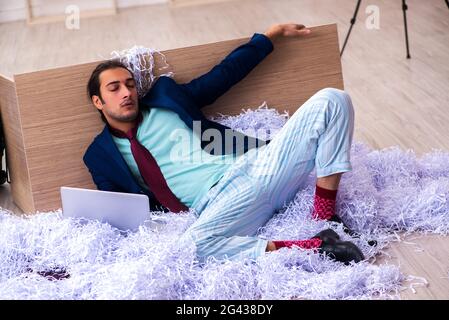 Young male employee and a lot of cut papers in the office Stock Photo